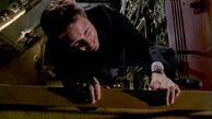 Fox Mulder hangs from a gantry, following the 'death' of Knowle Rohrer (The Truth)