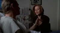 Daniel Waterston holds Scully's hand while in his hospital bed.