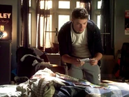 Riley In His Room With A Pile of Clothes Reading A Note