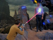 Kirk fires a phaser rifle at Mitchell