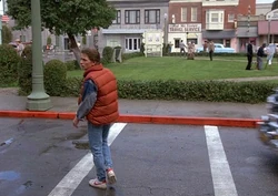 Marty McFly crosses the street in the square, unaware that he is blocking the path of a car.