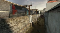 A Combine train passes by a canal and residential apartments.