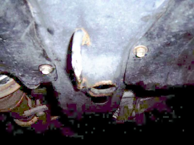 The front picture is kind of dim. It's right behind the tow point. It is designed for a bottle jack, but a standard or shop floor jack will function just fine.