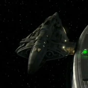 An Enolian shuttle docked with the Enterprise.