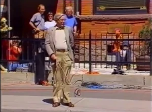 Gerry Parkes walks "Sprocket" with Whitmire and Nelson holding up puppets in background.