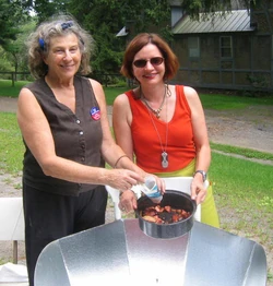 New York artist Mary Frank pictured on left with her CooKit solar panel cooker